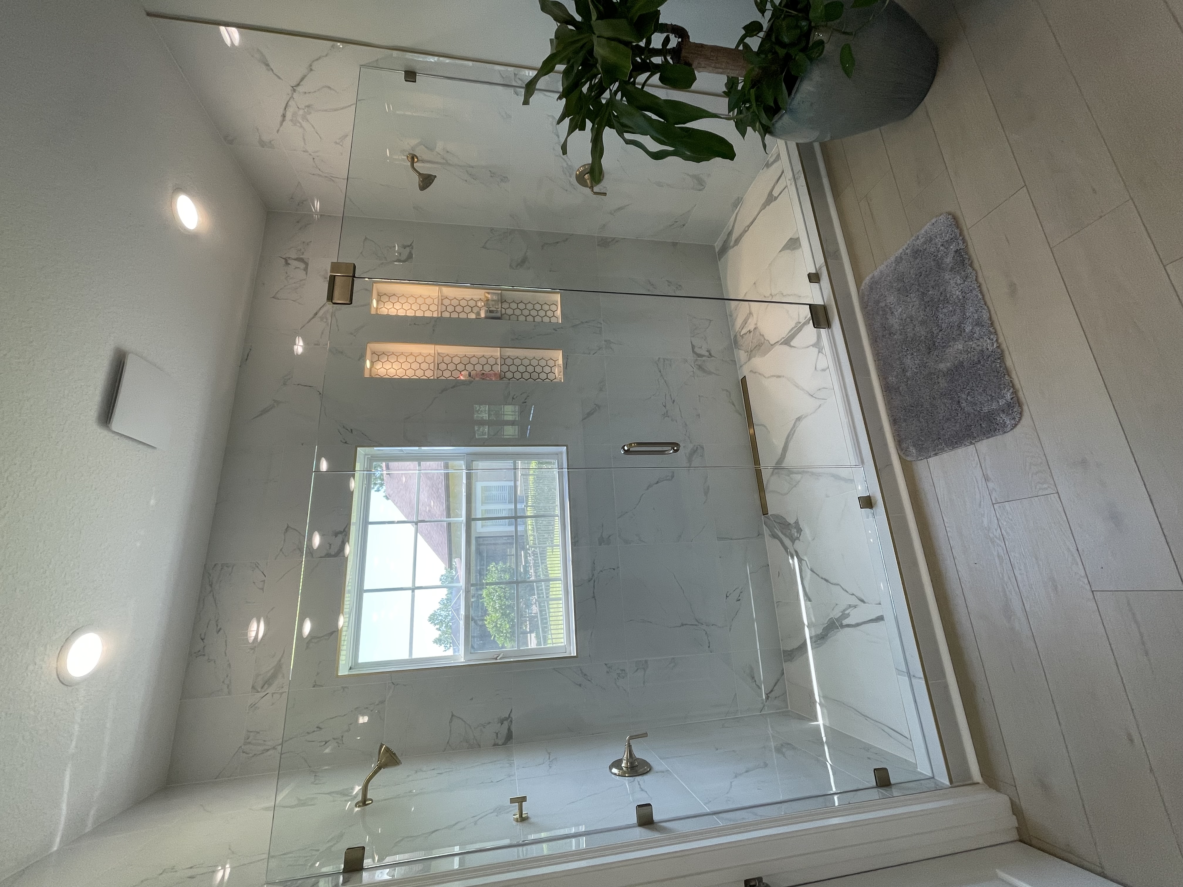 Completed Vertex bathroom with glass shower enclosure and illuminated niches