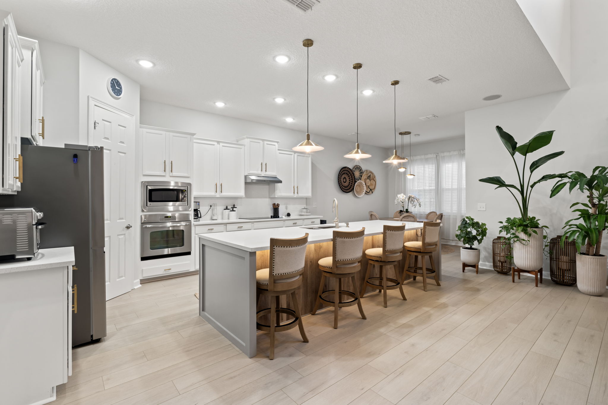 Completed Vertex kitchen with white cabinets and an illuminated island